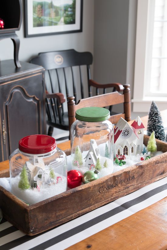 a wooden crate with jar snow globes and ornaments as a centerpiece
