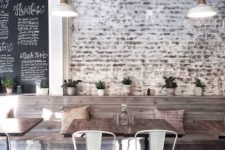 27 whitewashed brick walls, rough wood tables and metal chairs