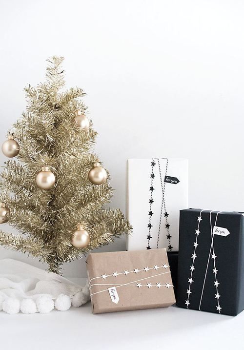 gold tabletop tree with gold ornaments and monochrome gifts