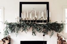 29 a greenery garland with lots of candles over the mantel