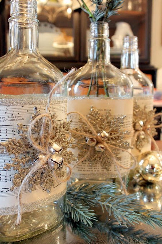 such bottles covered with music sheets, snowflakes and jingle bells can be DIYed and turned into vases