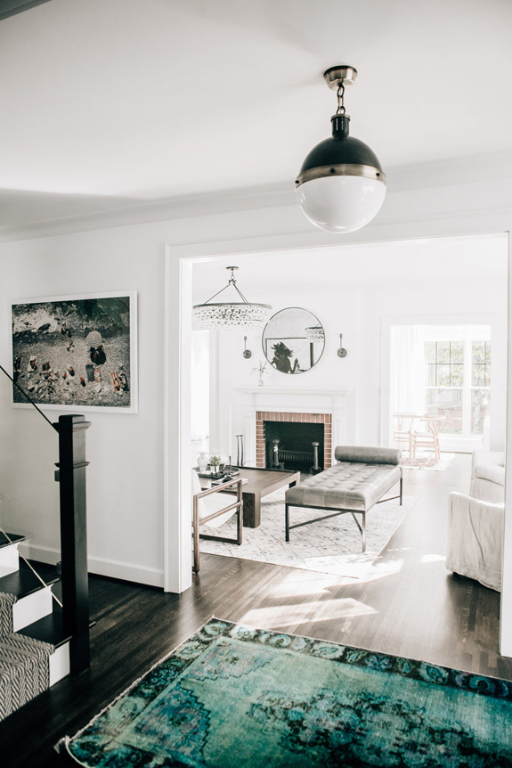 The entryway meets with dark wooden floors, cool pictures and a chic antique turquoise rug that makes the space pop up The entryway meets with dark wooden floors, cool pictures and a chic antique turquoise rug that makes the space pop up