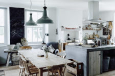 03 The kitchen is filled with light, the working surfaces are metal and concrete,  the furniture is wooden