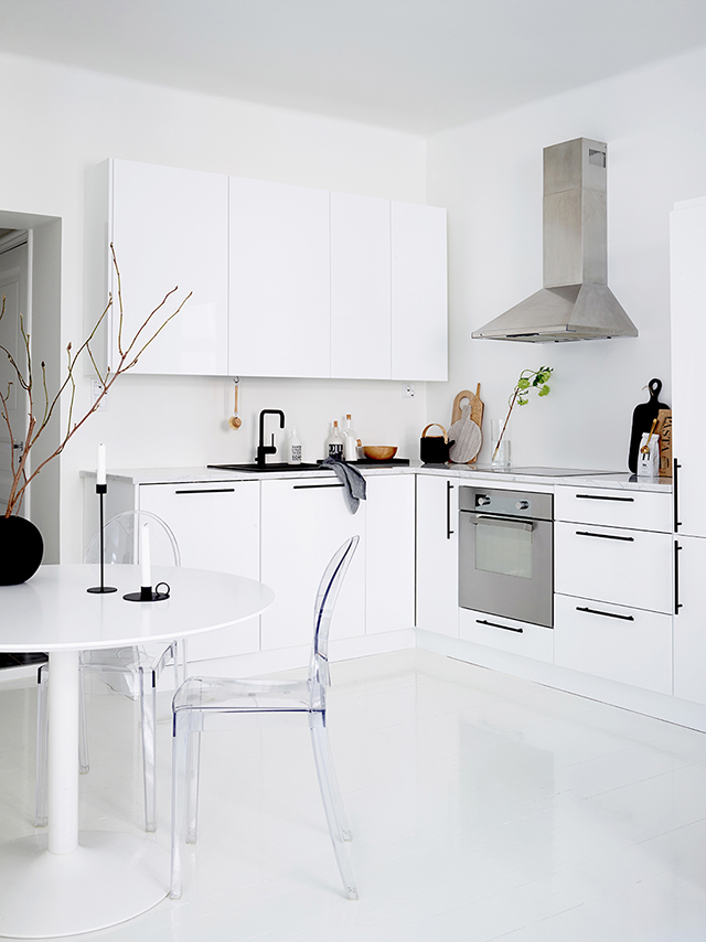 laconic kitchen design The kitchen is modern and laconic, with black handles that create a graphic feature and a lucite chair