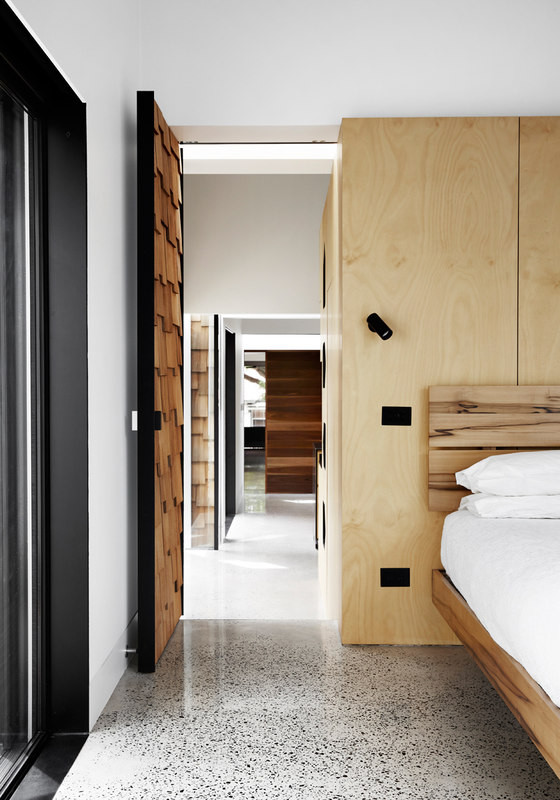 The master bedroom is decorated with light-colored wood, stone and the design is modern