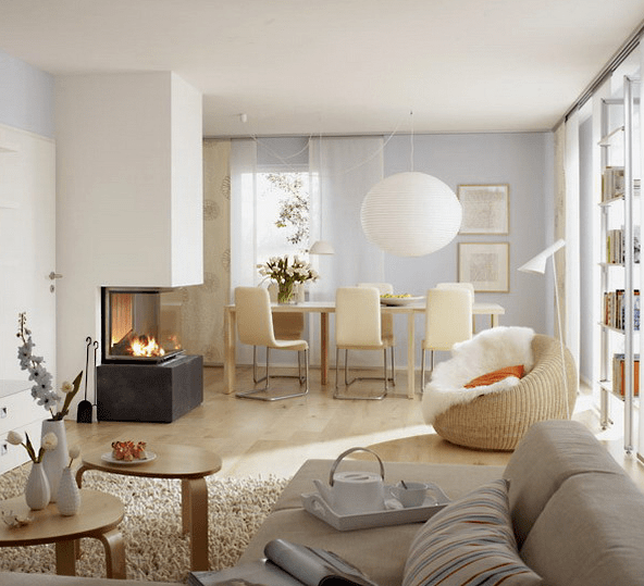 dining space is separated with a modern fireplace and a woven chair