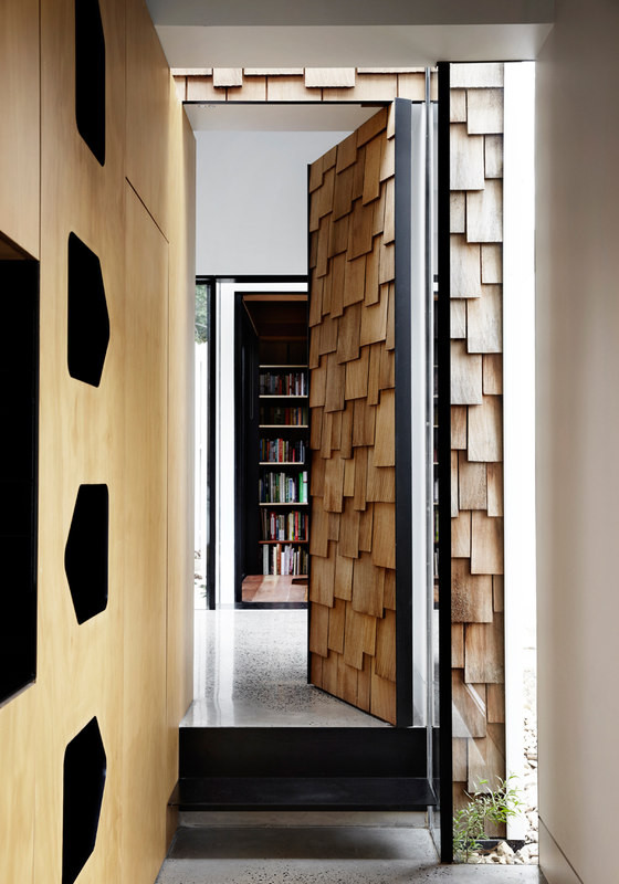 Unique light-colored wooden shingles cover doors, walls and some other surfaces, which is a unique feature of the house