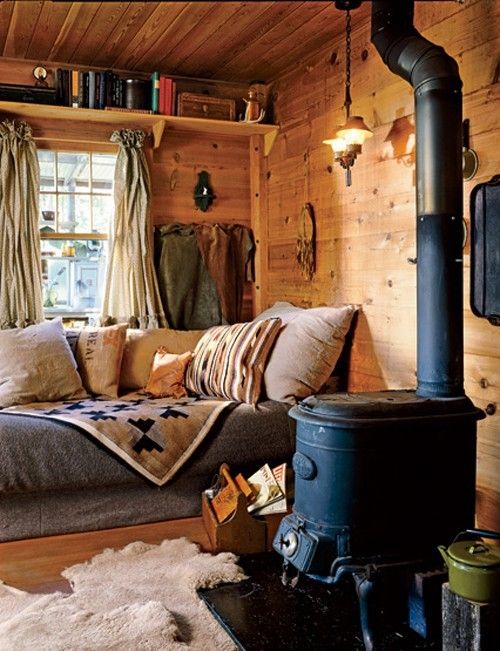  a sofa by the window with pillows and blankets