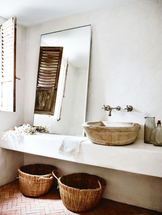 The master bathroom reminds of some Moroccan space due to the antique sink and woven baskets