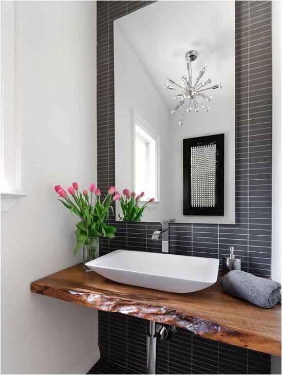 black and white graphic bathroom with a raw wood edge floating vanity