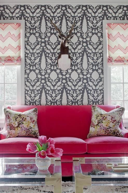 gorgeous fuchsia sofa in front of a patterned wall looks very bold