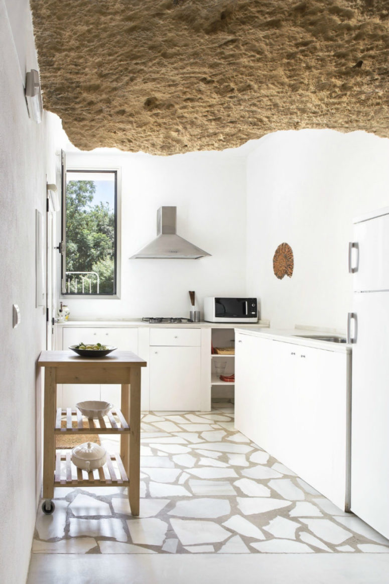 A window allows plenty of natural light in lighting up the white kitchen beautifully