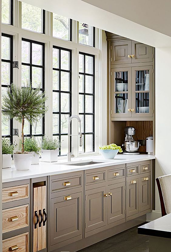 taupe kitchen with creay shades and brass handles looks chic