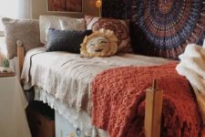 22 boho and vintage-inspired dorm room with a patterned rug on the wall and crochet blankets