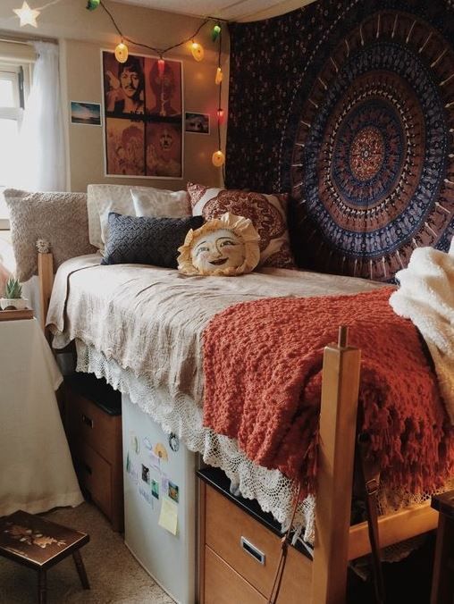 22 boho and vintage inspired dorm room with a patterned rug on the wall and crochet blankets