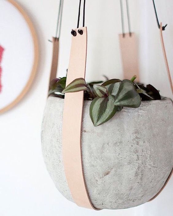 concrete pot on leather holders looks very modern