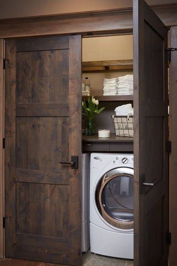 barnwood doors hide a laundry nook and echo with the shelves inside