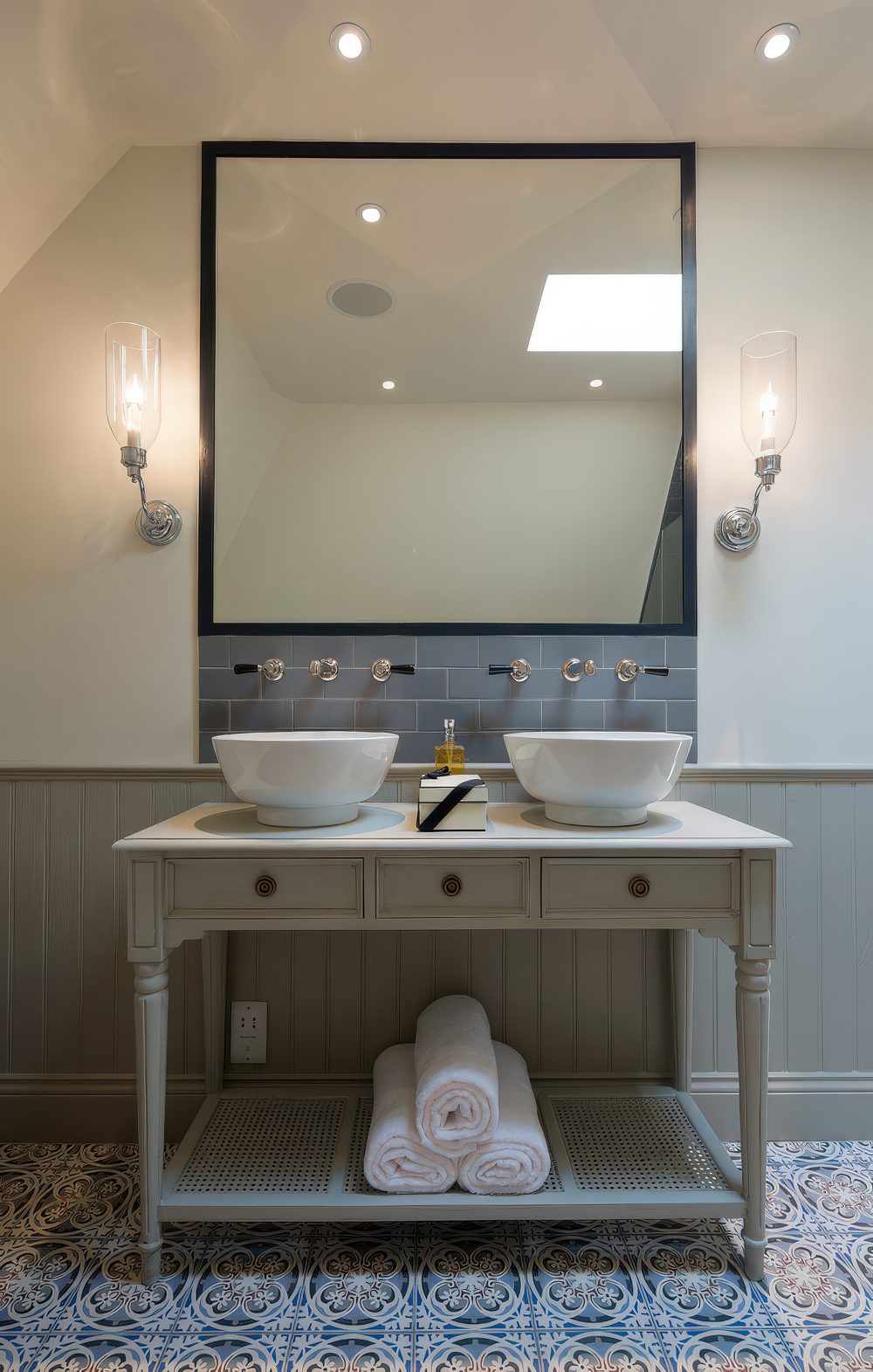 Neutral greyish-beige shabby chic vanity and wainscoting in the same color looks amazing in a mix with bold patterned flooring. (Peach Studio)