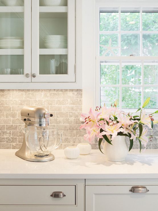 peaceful white kitchen with white quartz countertops and a marble-inspired backsplash