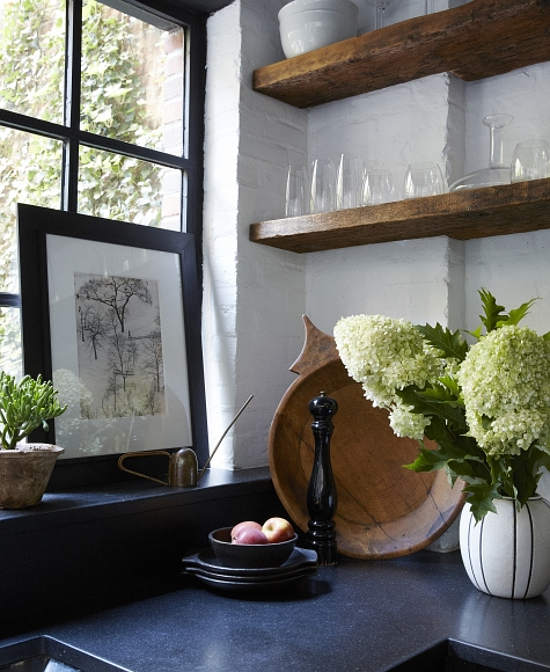 Plants, flowers and open shelving look great and contrasting with this space, and black granite counters match the best way possible
