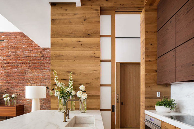 wood clad kitchen design The kitchen is clad with warm light-colored and chocolate-colored woods, with luxurious marble surfaces that eco with the coffee table