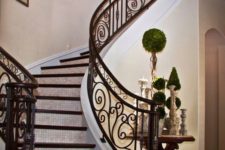 03 stunning indoor staircase of dark wood and custom-made wrought iron decor