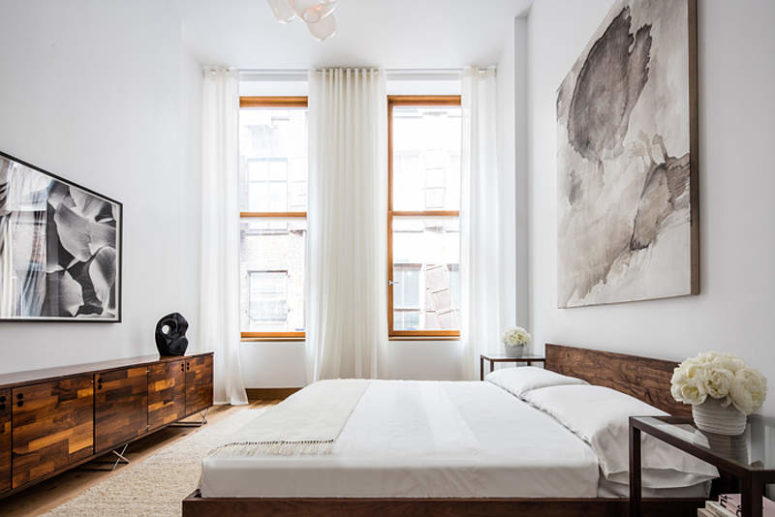 The bedroom is done in modern style, with graphic monochromatic artworks, a cool refined sideboard and lots of light coming in The bedroom is done in modern style, with graphic monochromatic artworks, a cool refined sideboard and lots of light coming in