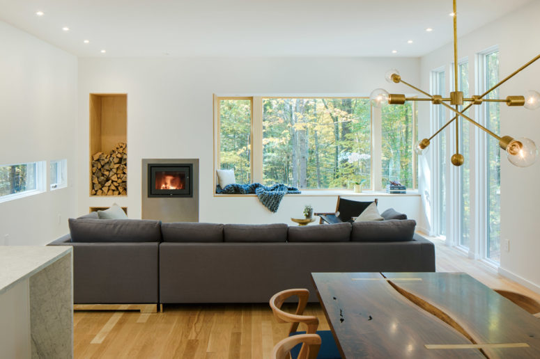 living room with a stylish firewood storage in a wall The living room features a comfy sofa next to the fireplace and firewood storage, there's a window sill to dream on it