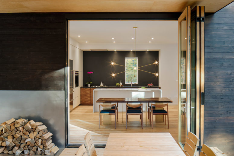 b&w kitchen design The kitchen is modern, black and white, with a waterfall kitchen island and a cool pendant lamp