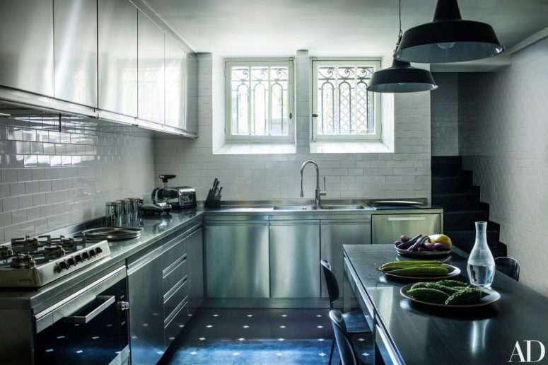 modern kitchen design The kitchen is modern, with simple white tiles and stainless steel cabinets and appliances, the lamps are vintage ones