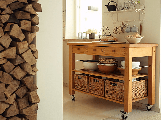 The kitchen island is made of wood, with baskets as drawers to give the kitchen a softer rustic look