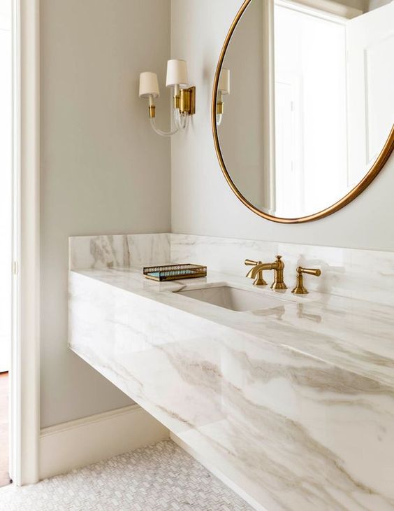 adorable sleek stone vanity with brass faucets