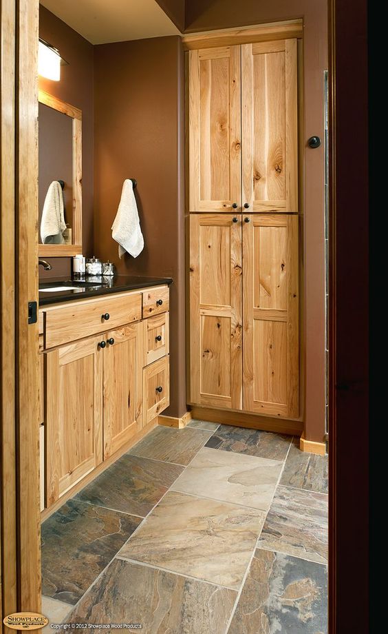 light-colored wood bathroom vanity with a black counter