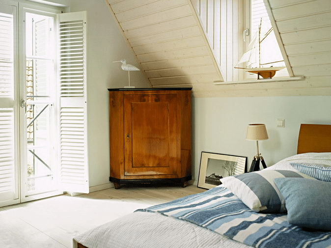 The bedroom decor is inspired by the sea holidays, there are several artworks and blue striped bedding The bedroom decor is inspired by the sea holidays, there are several artworks and blue striped bedding