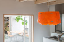 06 the kitchen is minimalist, with white cabinets, stainless steel surfaces and a warm woods, there’s an eye-catchy bold pendant lamp