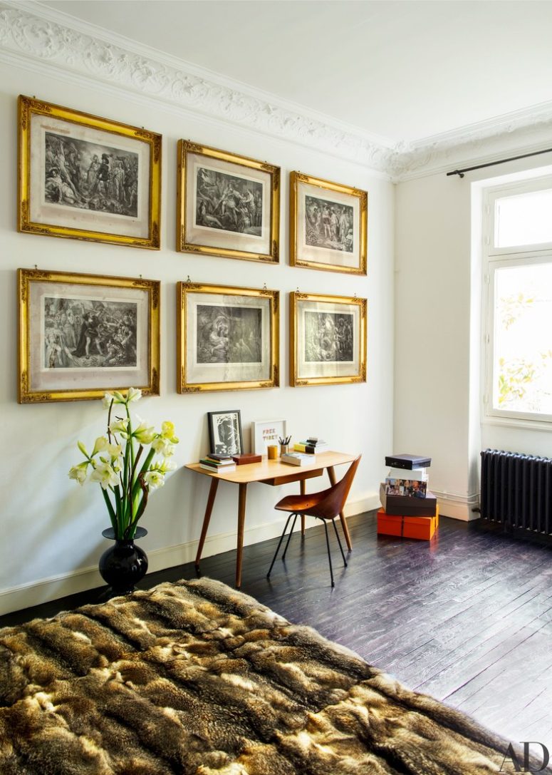 The master bedorom shows beautiful artworks in shining gold frames and small desk with a bent wood chair The master bedorom shows beautiful artworks in shining gold frames and small desk with a bent wood chair