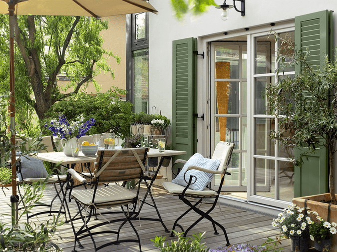The terrace features refined forged furniture with a vintage feel and lots of greenery and flowers