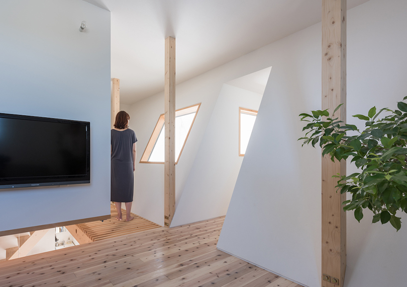 White walls are softened with light colored wooden floors and window framing
