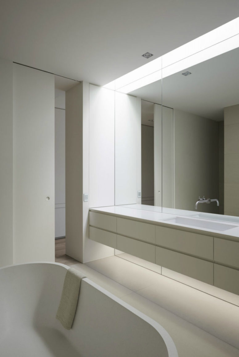 minimalist bathroom in white and a mirror wall with a vanity