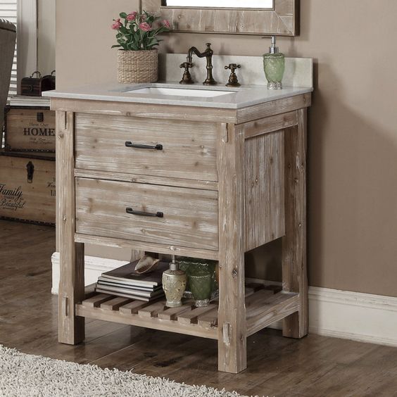 small whitewashed bathroom vanity with drawers and a shelf