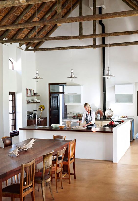 a modern farmhouse kitchen with a hearth and a rustic dining space with different chairs