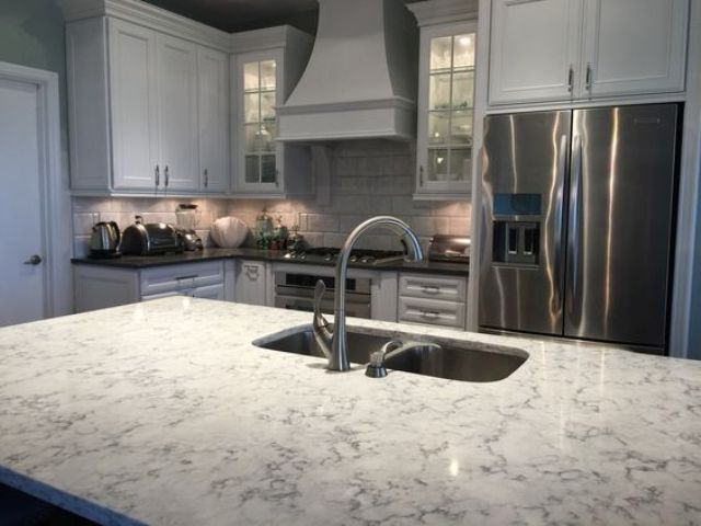 mmodern farmhouse kitchen in white with a white quartz counter on the kitchen island