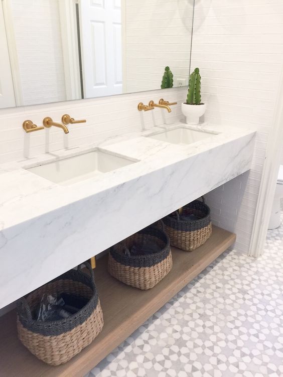 an upper marble surface and a lower wooden shelf with baskets