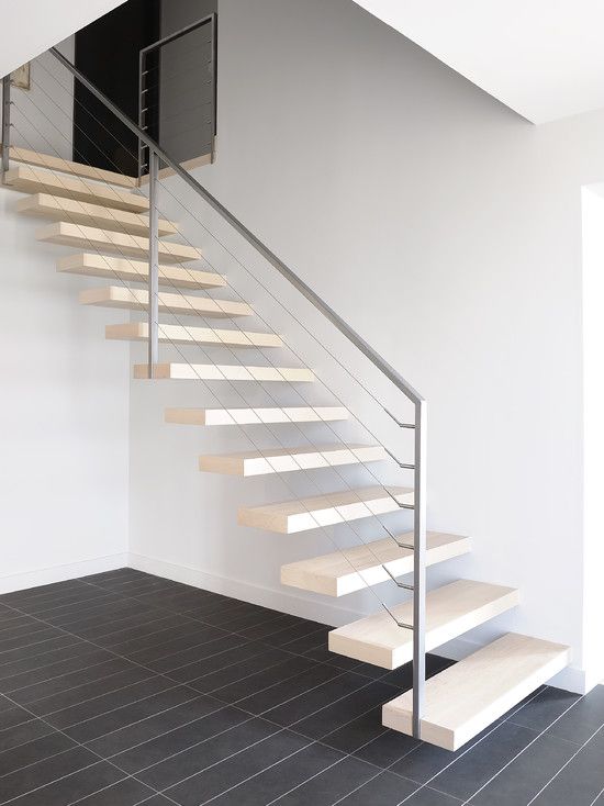 light-colored floating stairs with metal and cable railing