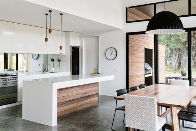 sleek white minimalist kitchen and a modern diner connected with colors and pendant lamps