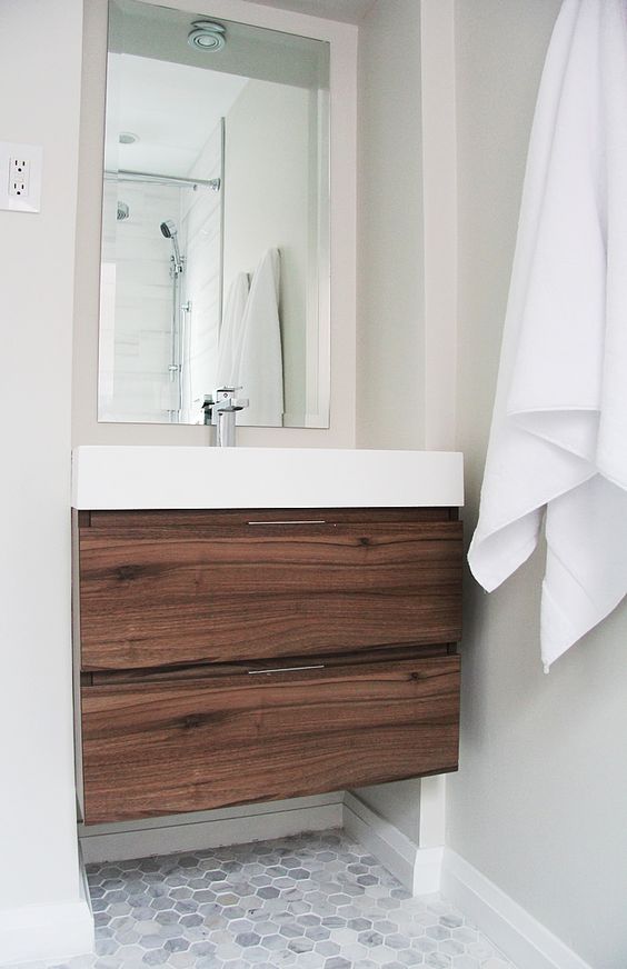 a small dark wood cabinet with drawers and a sink on top