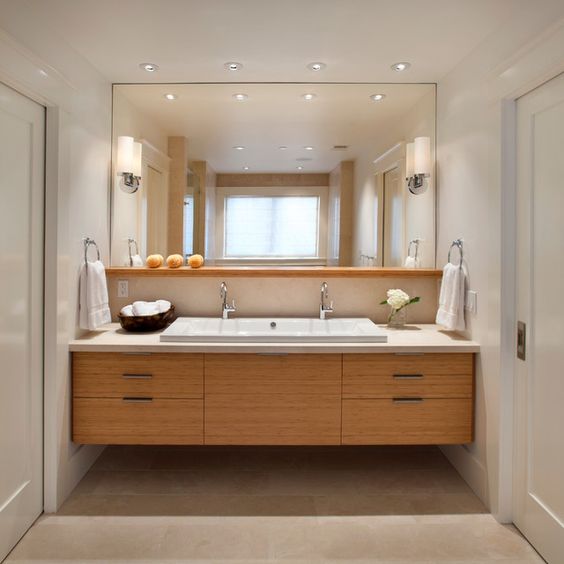 a warm-colored wooden vanity takes the whole niche here