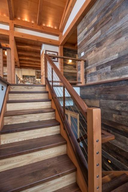 walnut stairs with stainless steel cable rails and wooden posts has a modern yet rustic look