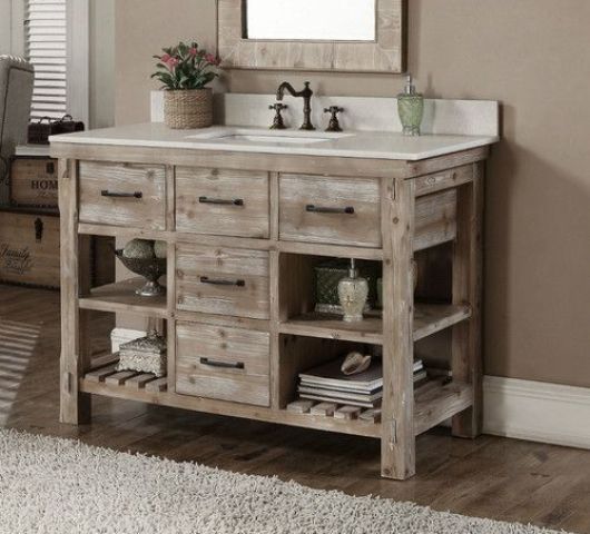 whitewashed reclaimed wood vanity with drawers and shelves and a white counter