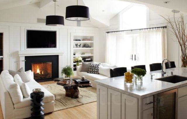 a modern kitchen merged with a small living room in black and white